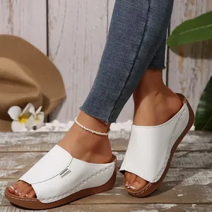Detailed side view of white comfortable wedge heel sandals featuring a peep-toe design