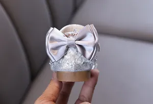 Vue détaillée de chaussure argentée pailletée pour fille avec nœud en satin élégant