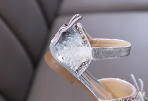 Détail de chaussures de princesse argentées à paillettes pour filles avec cristaux et nœud