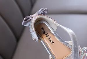 Détail de chaussure de princesse argentée pour fille avec logo de marque sur la semelle