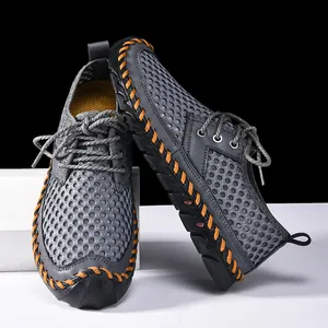 Macro view of grey mesh outdoor wading shoes with contrast orange hand-stitching.