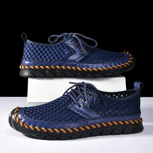 Close-up of blue mesh water shoes with decorative orange hand-stitching.