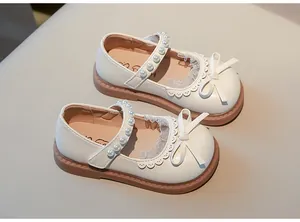 Elegantes zapatos Mary Jane para niña color crema con lazo y tira de perlas.