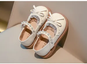 Primer plano de zapatos Mary Jane beige para niña con detalle de lazo y encaje