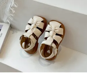 Close-up of cream toddler girls sandals with elegant double bow details and soft sole
