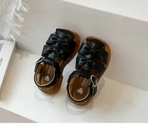 Close-up view of toddler girls black bow sandals with soft breathable soles for beach