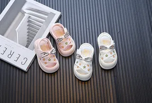 Zomersandalen voor peutermeisjes met strik en bloemenborduurwerk in roze en wit design.