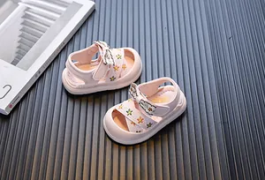 Detailopname van roze peutersandalen met bloemenborduurwerk en een schattig strikontwerp