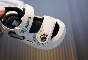 Close-up detail of white toddler light-up sandal with cute paw print and Fashion text