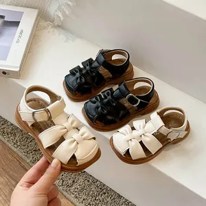 Closed-toe toddler girl sandals with cute bow detailing in black and cream leather