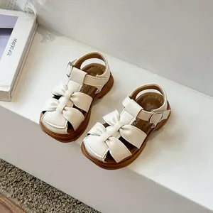 Cream white girls' closed-toe sandals featuring cute bow details and soft walking soles