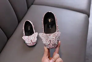 Primo piano di scarpe da principessa rosa glitterate con una grande farfalla di strass