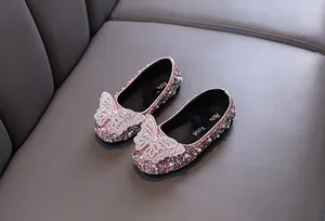 Dettaglio di scarpe da principessa rosa per bambine con strass e grande farfalla