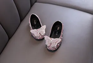 Dettaglio scarpe da principessa rosa per bambina con strass e decorazione a farfalla.
