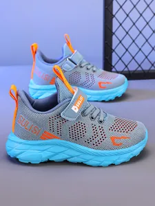 Detalle lateral de zapatillas de correr de malla azul para niños con tonos naranja