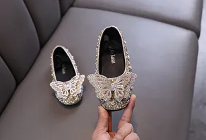 Dettaglio ravvicinato di scarpe da principessa per bambina con farfalla di strass
