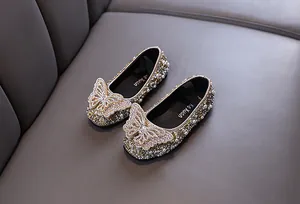Dettaglio ravvicinato di scarpe da principessa dorate per bambina con strass e perle