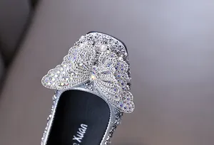 Dettaglio di scarpe da principessa argento per bambine con farfalla di strass luccicanti