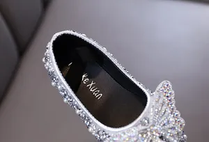 Vista ravvicinata di scarpe da principessa per bambina con strass e perle