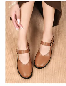Detailansicht der braunen Vintage Mary Jane Flats mit Schnallen auf Teppichboden