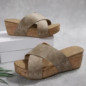 Macro detail view of stylish khaki platform wedge sandals featuring studded cross straps