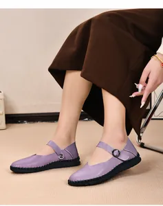 Nahaufnahme von eleganten lila Mary Jane Flachschuhen aus Leder mit verstellbarer Schnalle.