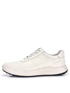 Perfil lateral detallado de una zapatilla casual de hombre en cuero blanco perforado.