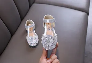 Close-up van fonkelende zilveren prinsessenschoenen voor meisjes met strass-bloem