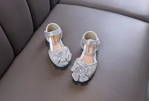 Detailopname van sprankelende zilveren prinsessenschoenen voor meisjes met bloem