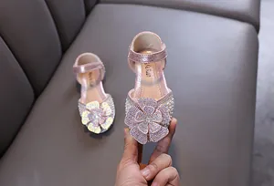 Close-up van roze prinsessenschoenen voor meisjes met strasbloem en pareldetails