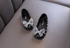 Exquisites Strass-Schmetterlingsdetail auf schwarzen glitzernden Prinzessinnenschuhen