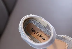 Detail van zilveren glitter prinsessenschoenen voor meisjes met parelhiel en logo