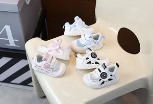 Group of breathable mesh toddler shoes in pink, blue, and black on a white chair