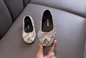 Nahaufnahme von Prinzessinnenschuhen für Mädchen mit Strasssteinen und Schleife