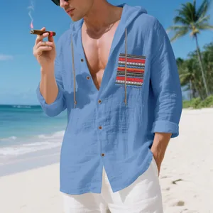 Detailed view of men's blue Bohemian linen hoodie shirt worn on a sunny tropical beach