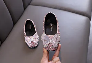 Makroansicht von rosa Mädchen-Prinzessinnen-Flats mit Strasssteinen und Schleife