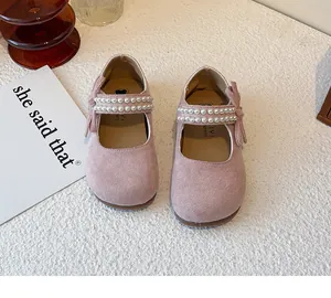 Detalle de zapatos Mary Jane de gamuza rosa para niña con tiras de perlas y un lazo