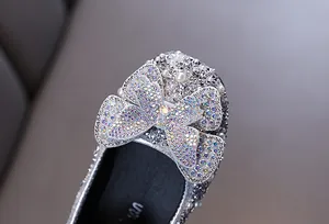 Detailansicht glitzernder silberner Strass-Prinzessinnenschuhe mit Schmetterlingsschleife