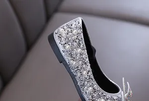 Detailansicht der glitzernden Strasssteine und Perlen auf silbernen Mädchenschuhen
