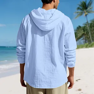 Detaillierte Rückansicht eines lockeren hellblauen Leinen-Kapuzenshirts am Sonnenstrand.