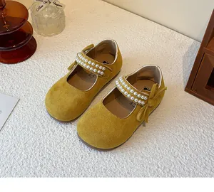 Primer plano de zapatos de princesa amarillos para niña con correas de perlas y un lazo elegante