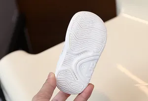 Detail macro shot of white baby walking shoe sole with anti-slip pattern and size 16