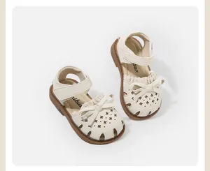 Top view of cream baby girls sandals with bow decoration and star laser cut details