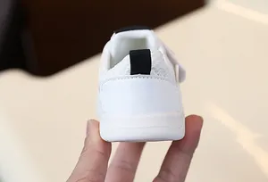 Close-up of white toddler shoe heel with breathable mesh and black pull tab