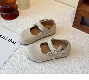 Zapatos Mary Jane beige para niña con tira de perlas y lazo, vista de detalle.