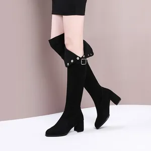 Elegant black suede over-the-knee boots with chunky heels and silver eyelet details