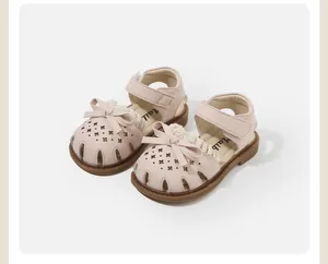 Close-up of pink toddler sandals with decorative bows and hollow star patterns.