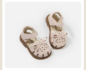 Detailed view of baby girl pink sandals with cute bow decoration and hollowed out stars.