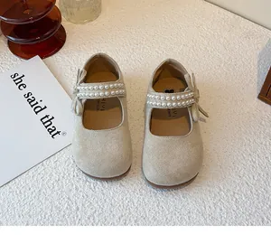 Vista superior de merceditas beige para niña con tiras de perlas y adornos de lazos.