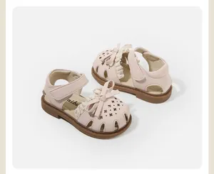 Detailed close-up of pink baby girl sandals featuring decorative bow and elegant lace trim